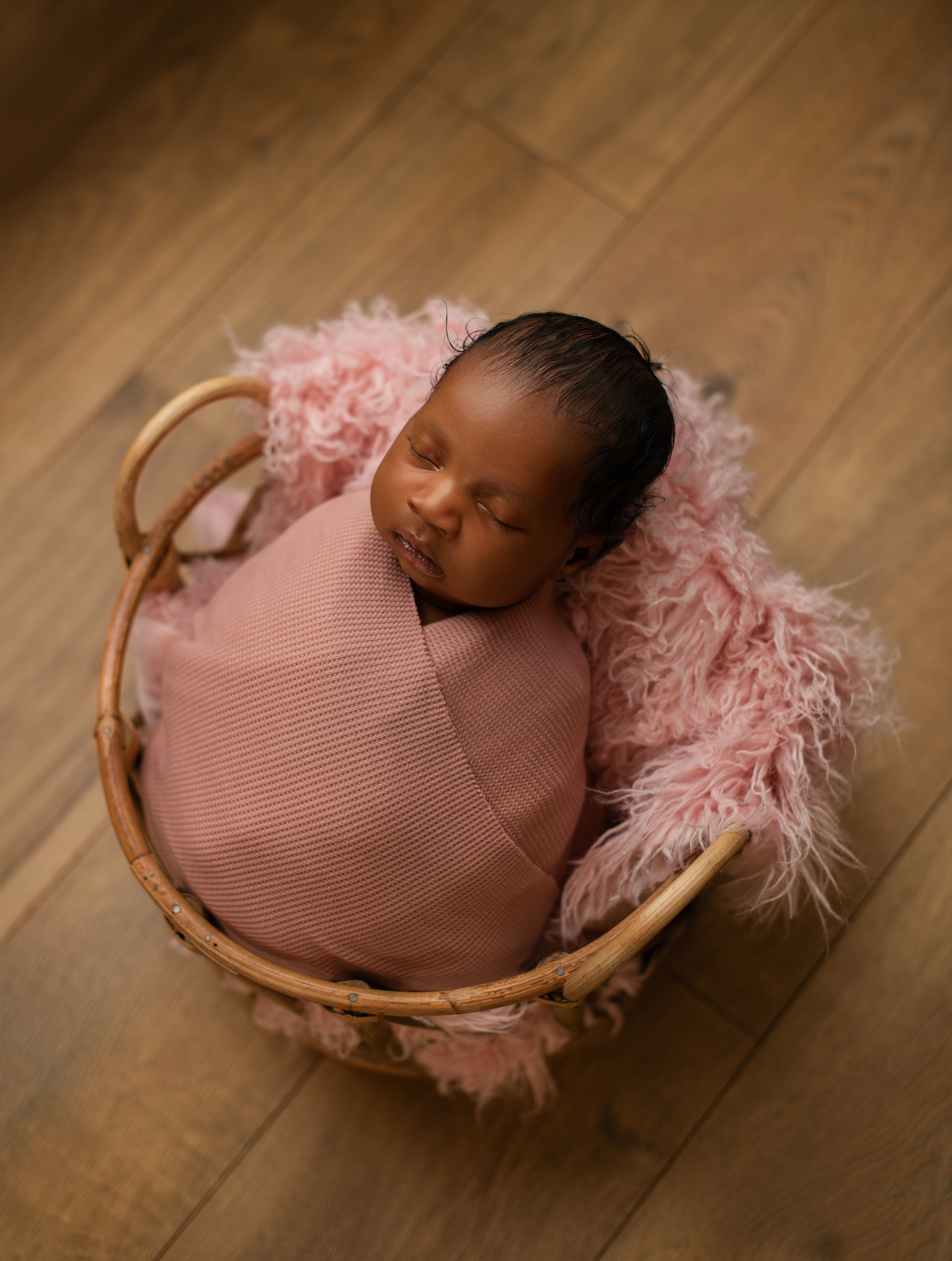 Baby girl in a basket part of Snapzbytie Photography's newborn photography prop