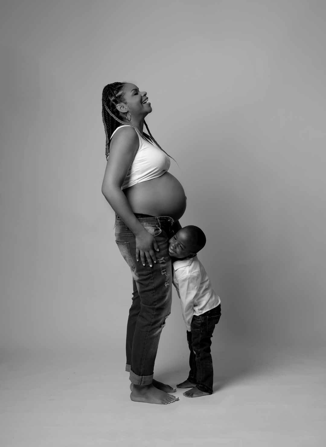 Mom and Eldest son laughing unposed in a black and white maternity photo