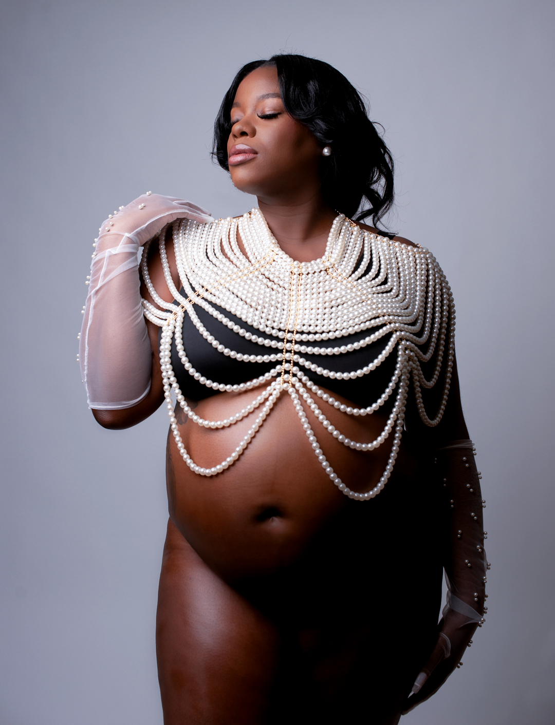 Expecting mom wears pearl necklace for maternity session.